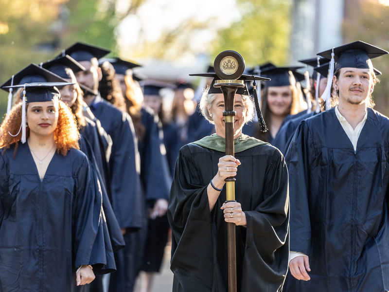 Penn State Hazleton graduates walking side by side down a sidewalk.